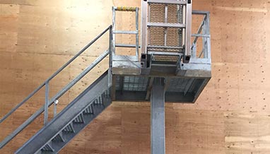 Truck platform with drop gangway for workers to access the top of trucks and trailers during loading and unloading.